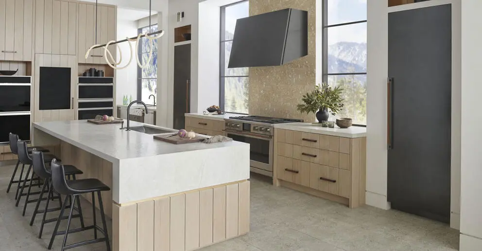 A modern kitchen featuring a spacious island and a stove, showcasing a clean and organized cooking space.